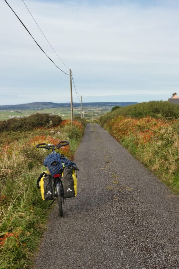 Vélo de voyage sur une route fleurie en Irlande